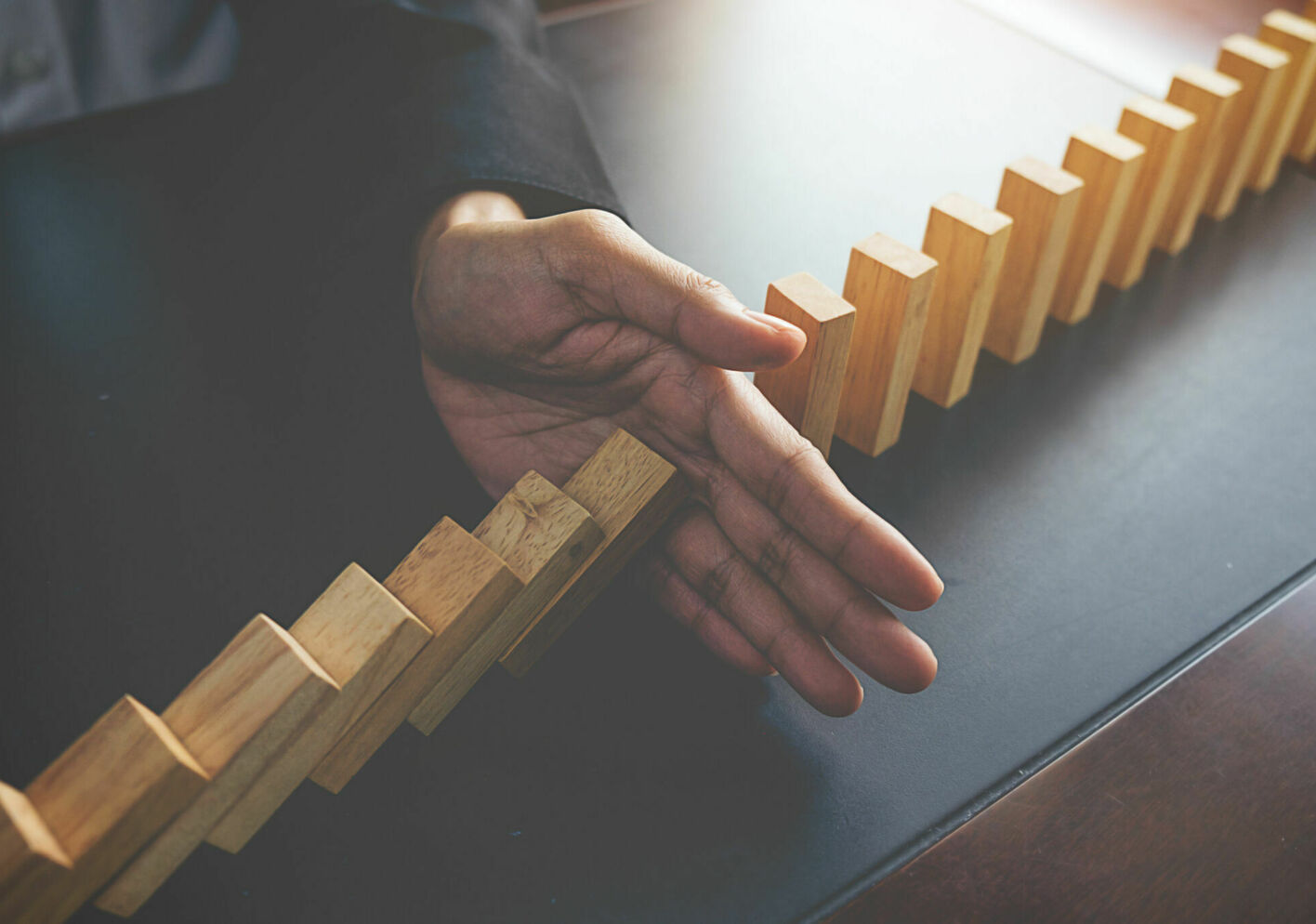 Problem solving close up view hand business woman stopping falling blocks table concept about taking responsibility