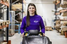 Schoonmaakster met schoonmaakmachine in de lens kijkend zoom portrait