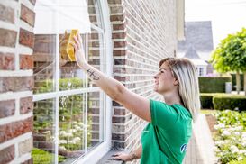 Vrouw wast het raam van buiten 2019