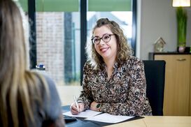 Vrouw luistert naar klant en noteert op papier 2020